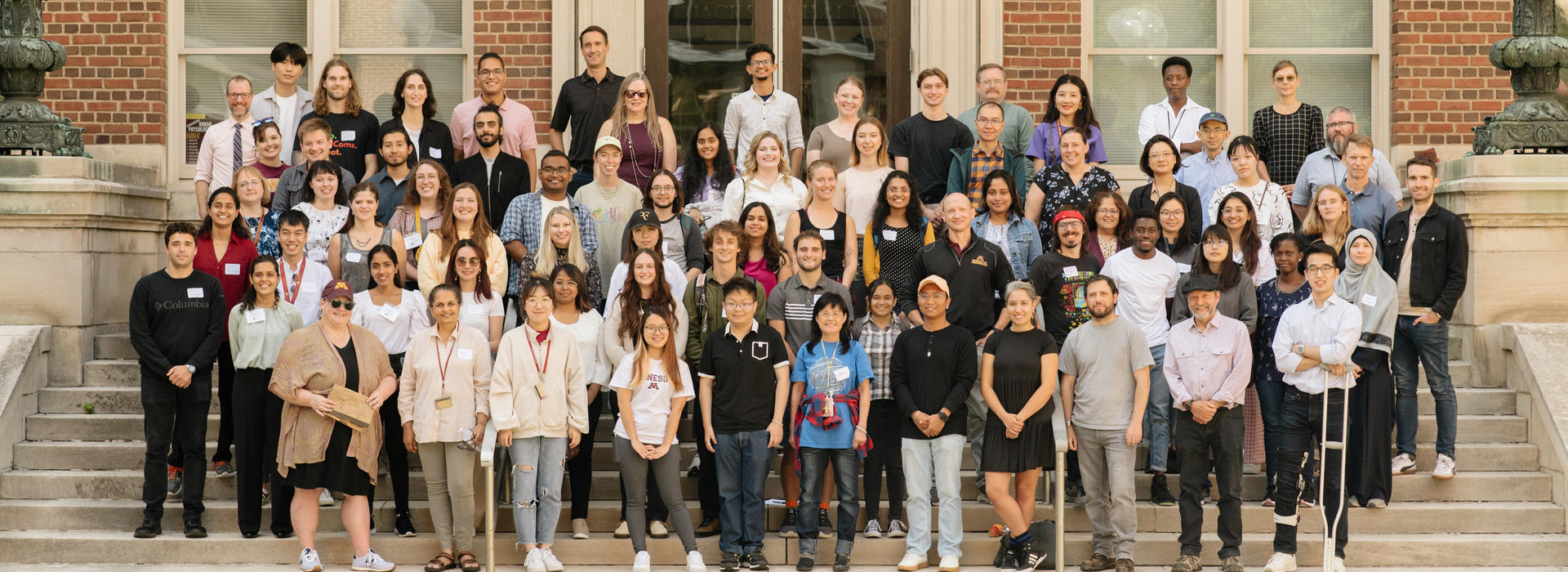 Group photo of faculty, students, and staff standing on outdoor steps to Jackson Hall